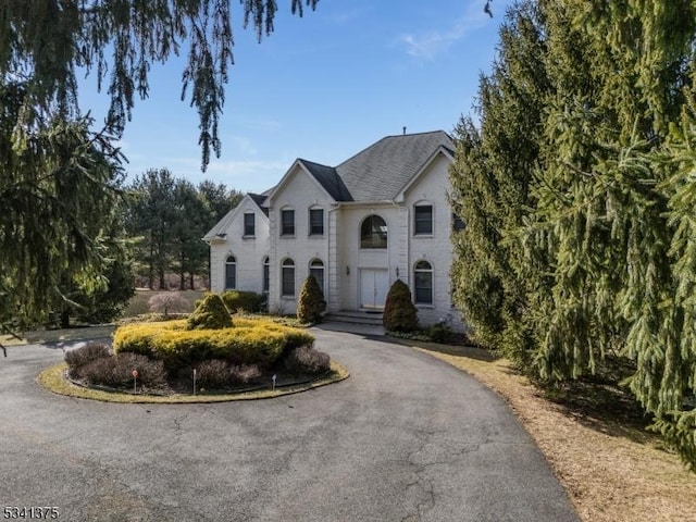 french country style house with brick siding and driveway