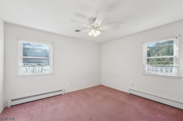 spare room with a baseboard heating unit, carpet, and a healthy amount of sunlight