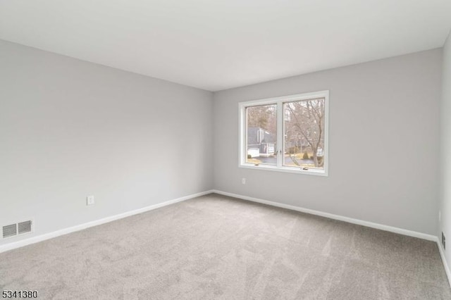 unfurnished room with baseboards, visible vents, and carpet flooring