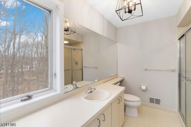 bathroom featuring a stall shower, visible vents, a notable chandelier, and vanity