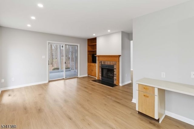 unfurnished living room featuring light wood-style floors, a fireplace, and baseboards