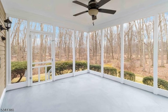 unfurnished sunroom featuring ceiling fan and a wealth of natural light