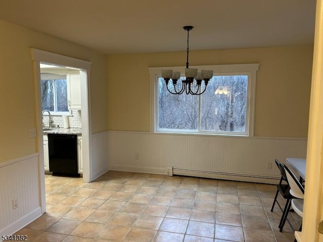 unfurnished dining area with a wainscoted wall, light tile patterned floors, a baseboard radiator, and a chandelier