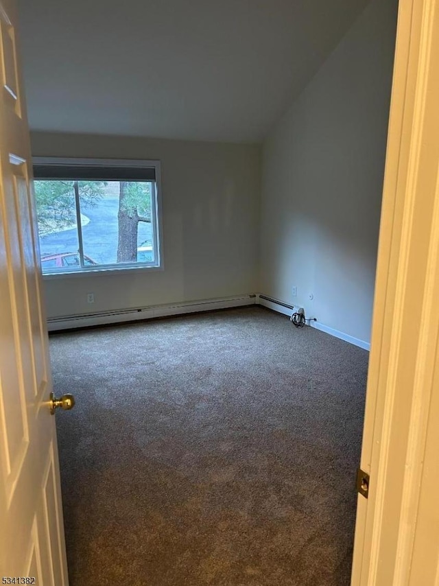 carpeted empty room featuring lofted ceiling, baseboard heating, and baseboards