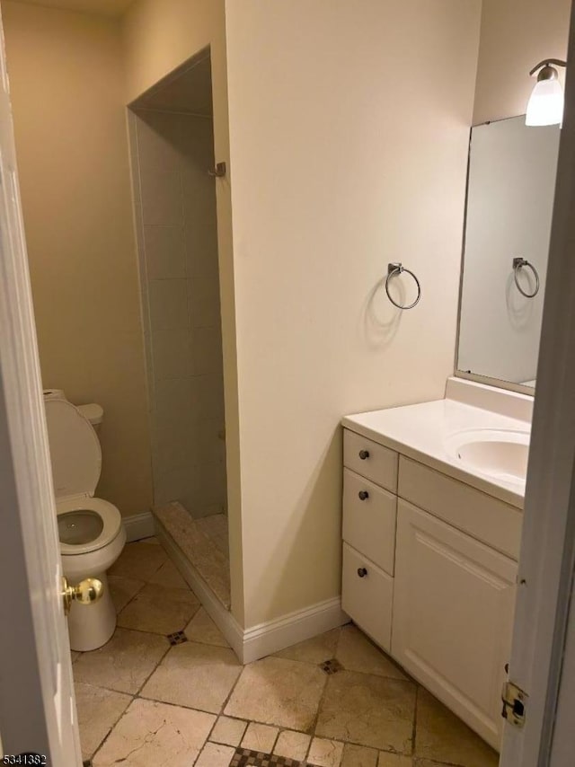 full bathroom featuring toilet, a shower stall, baseboards, and vanity