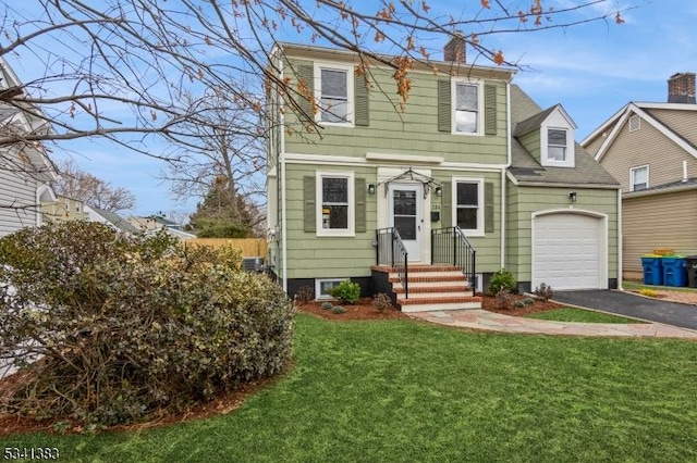 view of front of house with aphalt driveway, a chimney, an attached garage, central AC unit, and a front yard