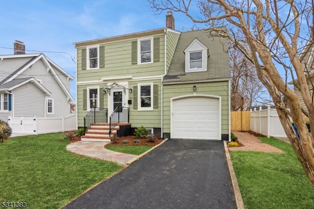 view of front of home featuring aphalt driveway, a front lawn, a chimney, and fence