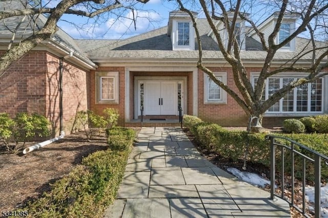 view of exterior entry featuring brick siding