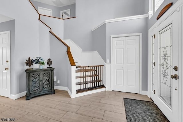 entrance foyer with a towering ceiling, baseboards, and stairs