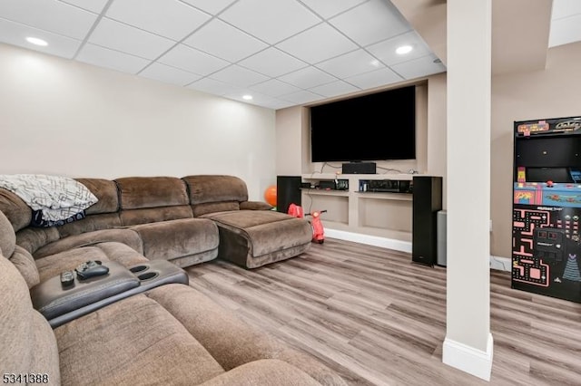 living area with recessed lighting, a drop ceiling, wood finished floors, and baseboards