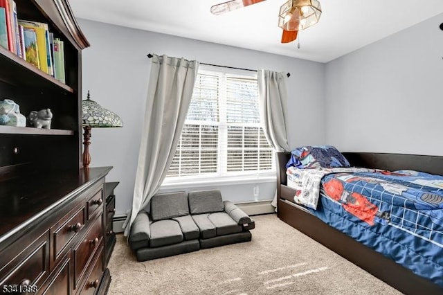 bedroom with a baseboard heating unit, carpet floors, and a ceiling fan