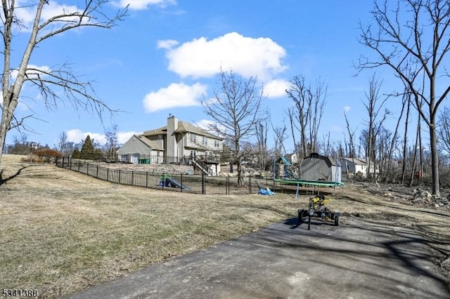 exterior space featuring a trampoline and fence