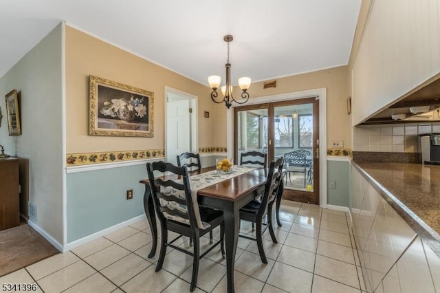 dining area featuring a chandelier, wainscoting, light tile patterned flooring, and visible vents