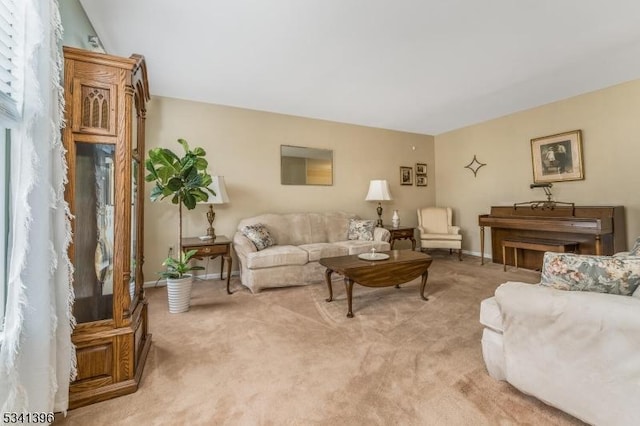 living area with baseboards and light colored carpet