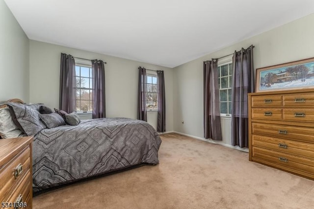 bedroom featuring light carpet and baseboards