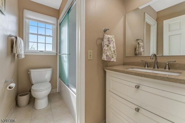 bathroom with toilet, tile patterned floors, baseboards, and vanity