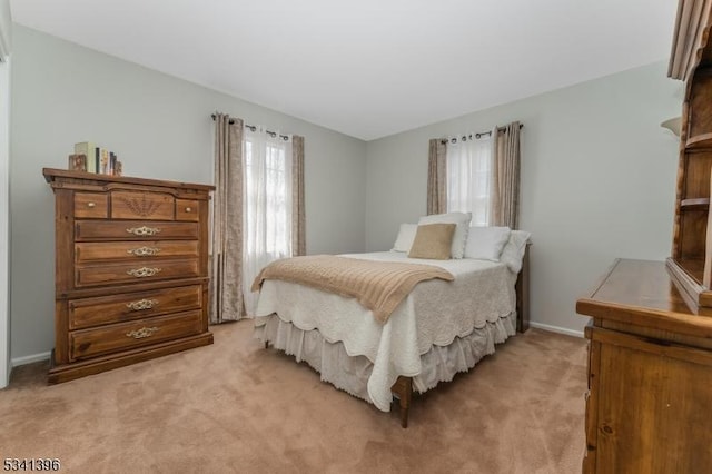 bedroom with light carpet and baseboards