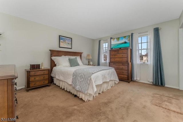 bedroom featuring light carpet and baseboards