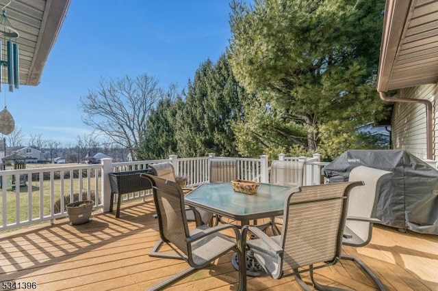 wooden terrace featuring outdoor dining space and area for grilling