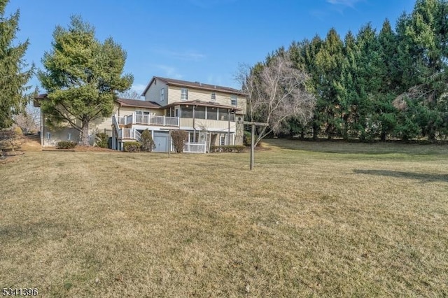 rear view of property featuring a sunroom and a lawn