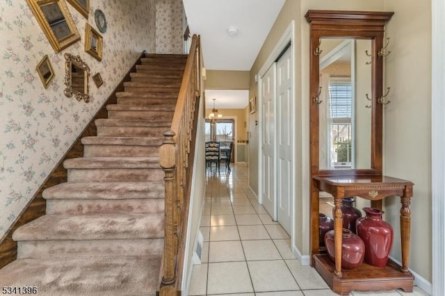 stairway featuring tile patterned flooring, a wealth of natural light, and wallpapered walls