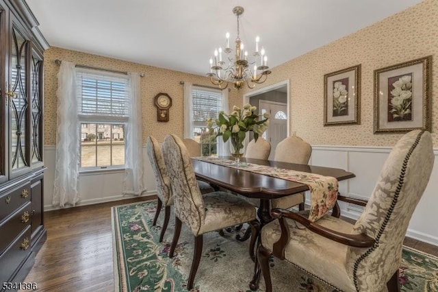 dining area with a healthy amount of sunlight, a wainscoted wall, dark wood-style flooring, and wallpapered walls