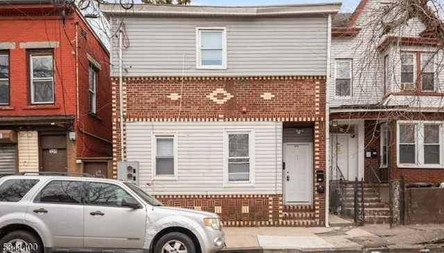 townhome / multi-family property featuring entry steps and brick siding