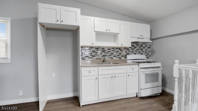 kitchen with lofted ceiling, under cabinet range hood, a sink, white cabinetry, and white range with gas cooktop