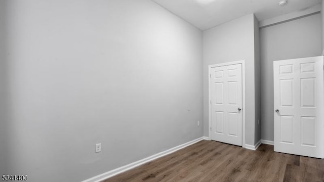 unfurnished bedroom with baseboards and wood finished floors