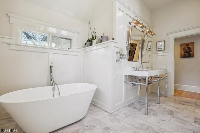 bathroom with a freestanding bath and marble finish floor