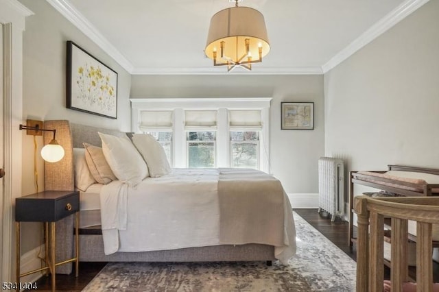 bedroom featuring ornamental molding, wood finished floors, radiator heating unit, baseboards, and a chandelier