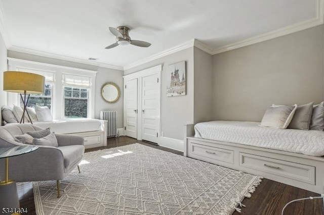 bedroom with baseboards, radiator, wood finished floors, and crown molding