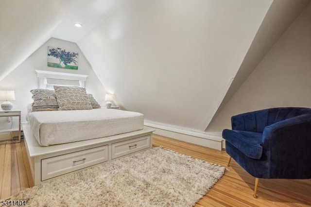 bedroom with lofted ceiling and light wood-style flooring