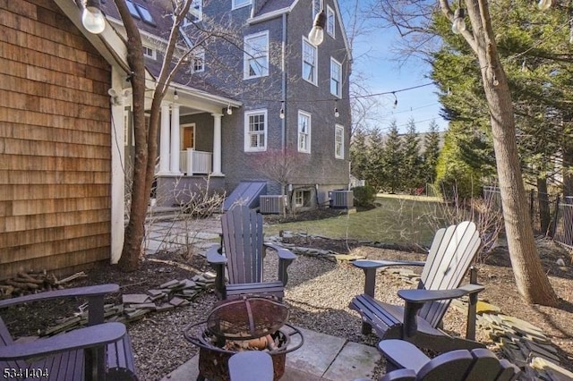 view of yard featuring fence, central AC, and an outdoor fire pit