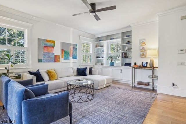 interior space with a ceiling fan, a healthy amount of sunlight, wood finished floors, and crown molding