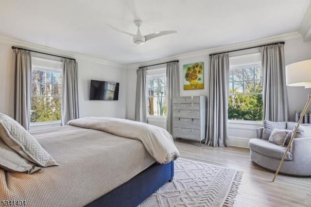 bedroom with ceiling fan, wood finished floors, and ornamental molding