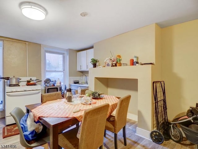 dining space with baseboards and light wood finished floors