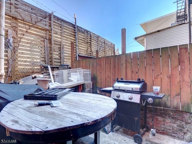 view of patio / terrace with fence and a grill