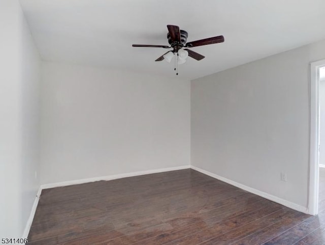 empty room featuring baseboards, dark wood-type flooring, and ceiling fan