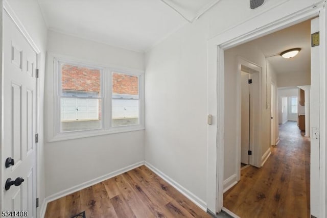 hallway with baseboards and wood finished floors