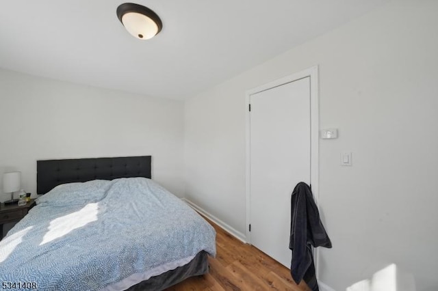 bedroom featuring baseboards and wood finished floors