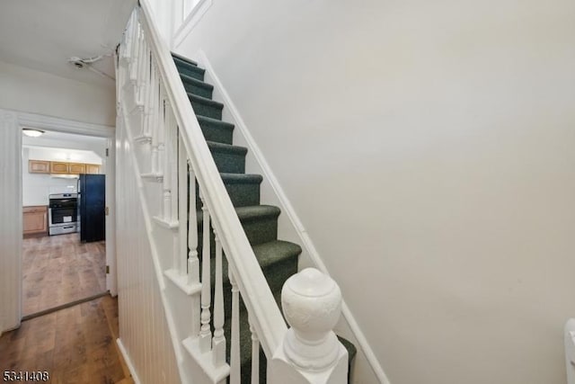 stairs featuring wood finished floors and baseboards