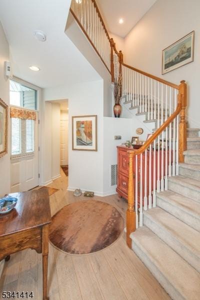 staircase featuring visible vents, recessed lighting, baseboards, and wood finished floors