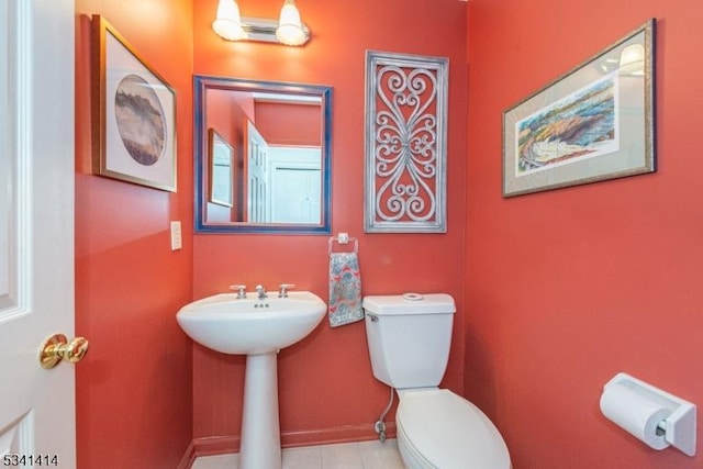 bathroom featuring toilet and baseboards