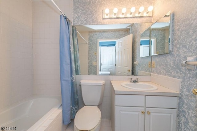 full bathroom featuring toilet, wallpapered walls, vanity, and tiled shower / bath