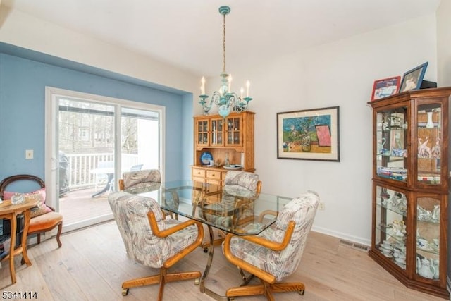 dining room with visible vents, baseboards, light wood-style floors, and an inviting chandelier