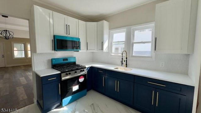 kitchen with blue cabinets, a wealth of natural light, stainless steel range with gas stovetop, and a sink