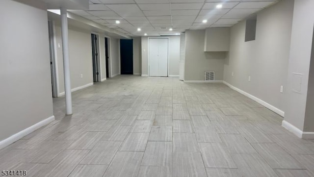 finished basement with recessed lighting, a drop ceiling, visible vents, and baseboards