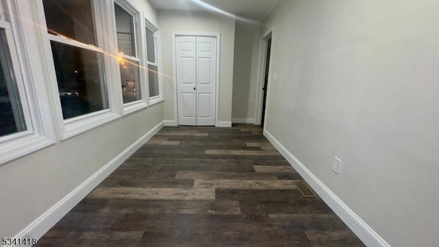 hallway with baseboards and wood finished floors