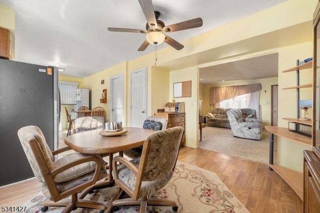 dining area featuring light wood finished floors and a ceiling fan